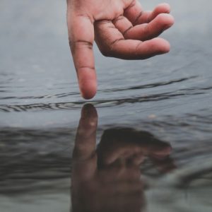 Hand creates ripples in the water
