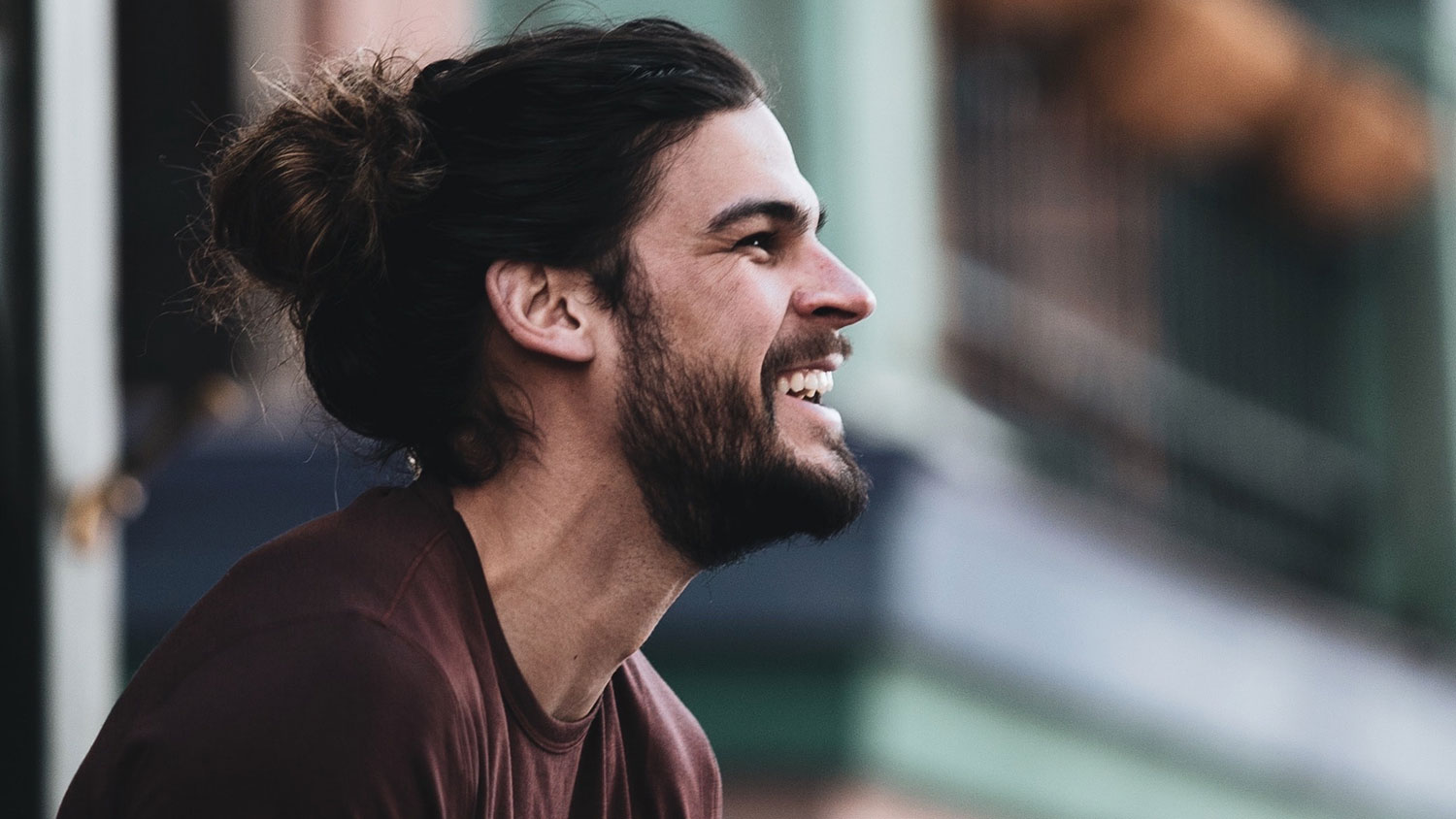 Profile of smiling Male with man-bun