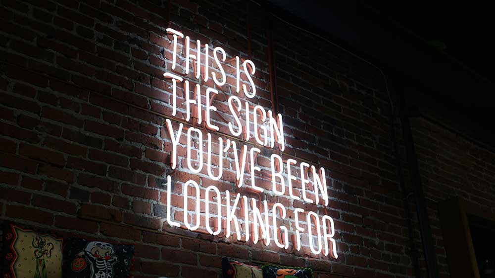 Illuminated sign saying 'This is the sign you've been waiting for